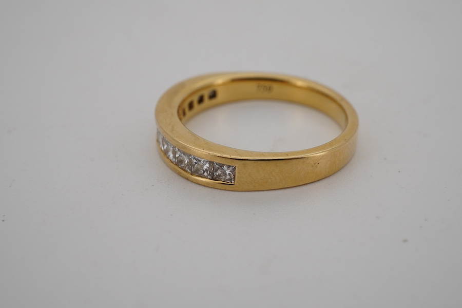 A diamond half hoop ring, channel-set to the front with princess-cut diamonds totalling approximately 0.60 carats, mounted in 18ct gold, size L, British hallmarks, gross weight approximately 4 grams